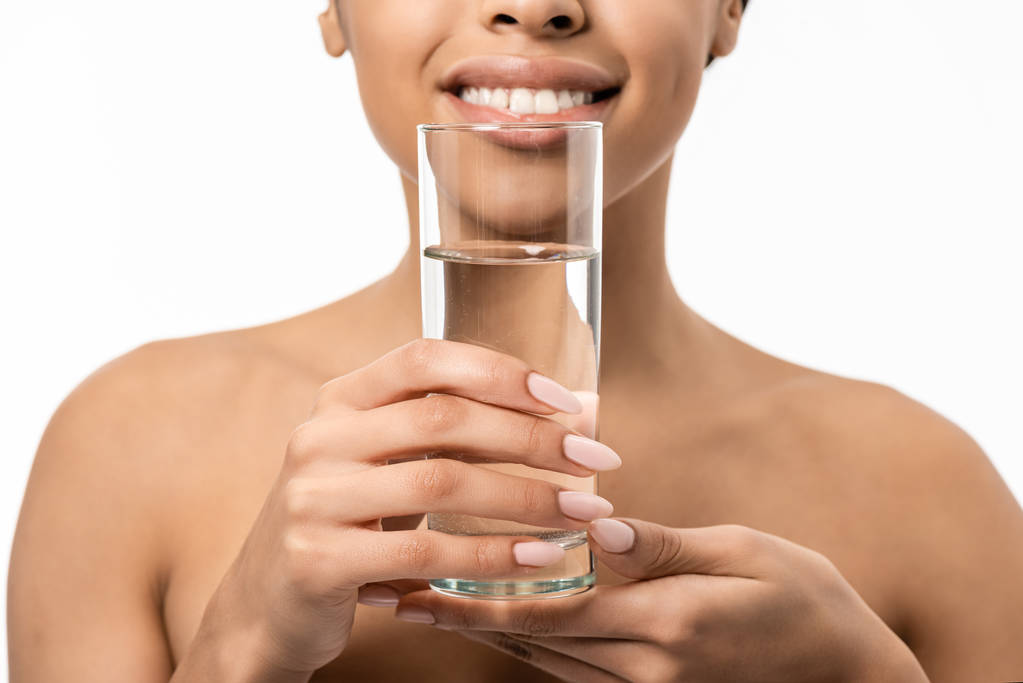 abgeschnittene Aufnahme von glücklichen nackten afrikanisch-amerikanischen Mädchen mit Glas Wasser isoliert auf weiß - Foto, Bild