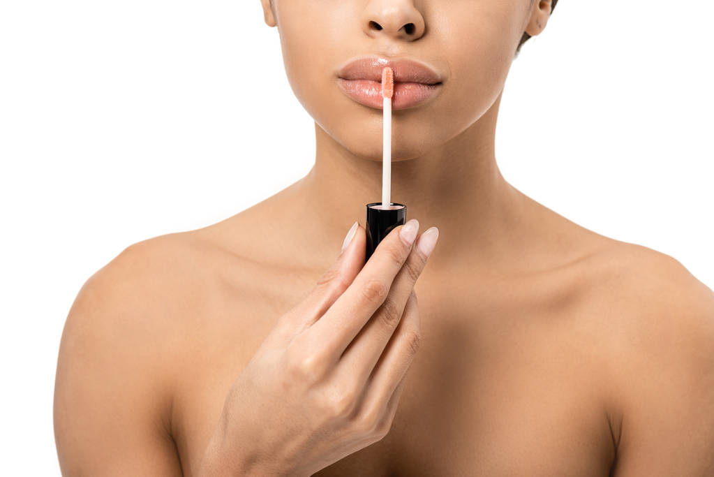 plan recadré de jeune femme africaine américaine nue appliquant gloss lèvres isolées sur blanc
  - Photo, image