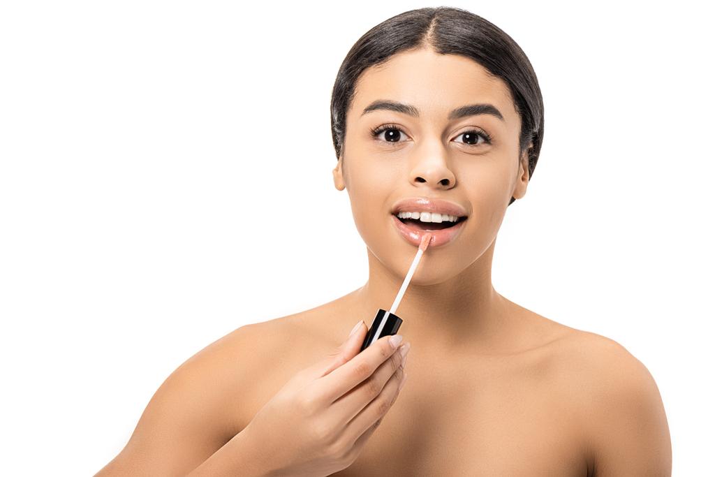 beautiful naked african american woman applying lip gloss and smiling at camera isolated on white - Photo, Image