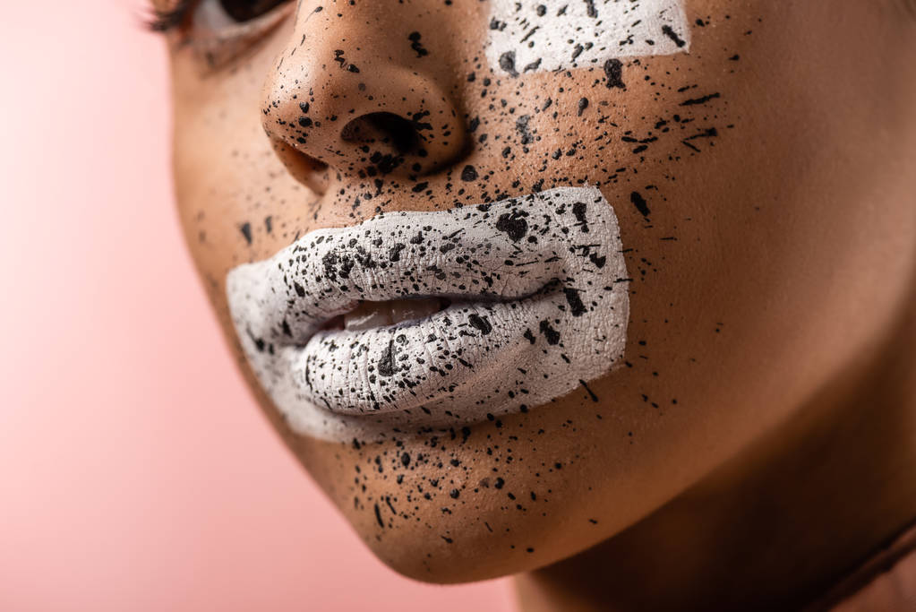 oříznuté záběr krásné afroamerické ženy s bílou barvou a hnědé šplouchá na obličej izolované na růžové - Fotografie, Obrázek