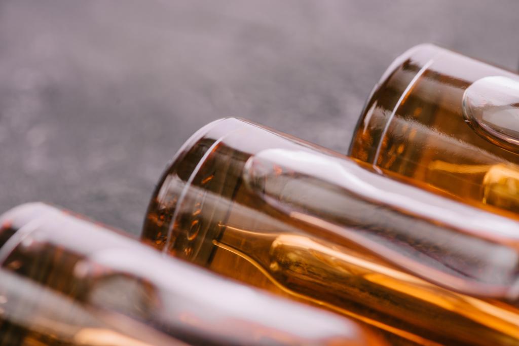 Close up van flessen met cbd olie op een grijze achtergrond - Foto, afbeelding