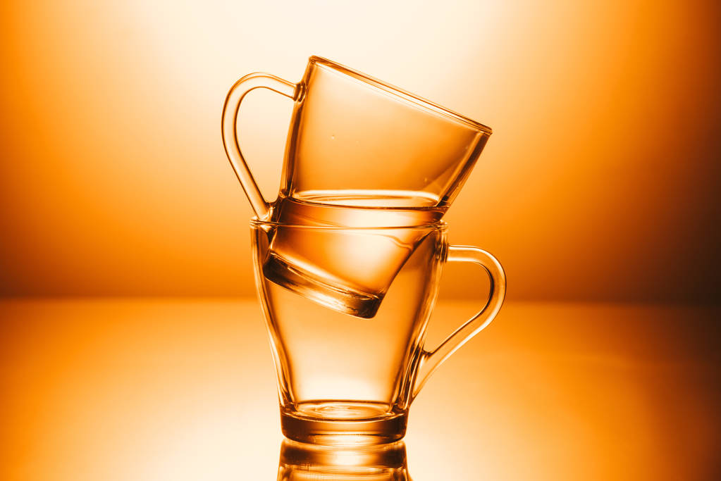 selektiver Fokus von zwei Tassen Tee auf orangefarbenem Hintergrund - Foto, Bild