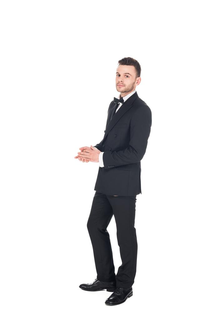 Красивый молодой человек позирует в черном смокинге и галстуке лук изолирован на белом
 - Фото, изображение