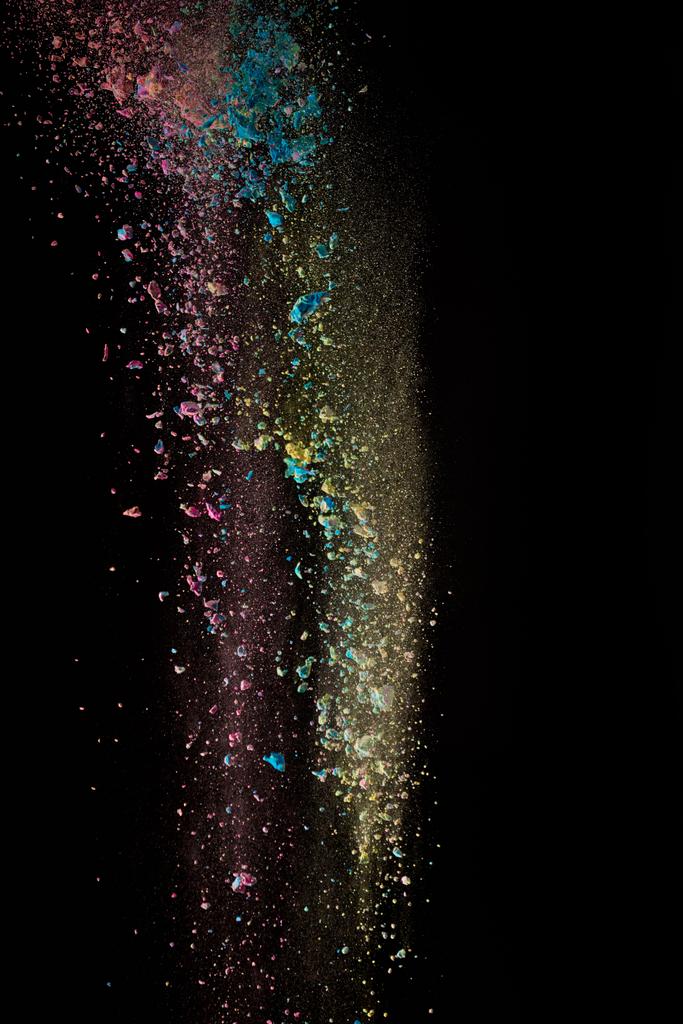  red, yellow and blue powder in air on black background - Photo, Image