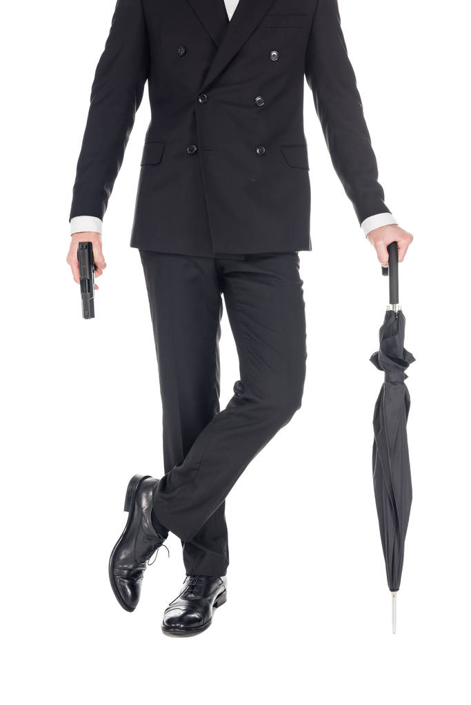 abgeschnittene Ansicht eines Geheimagenten mit Handfeuerwaffe und Regenschirm, isoliert auf weiß - Foto, Bild