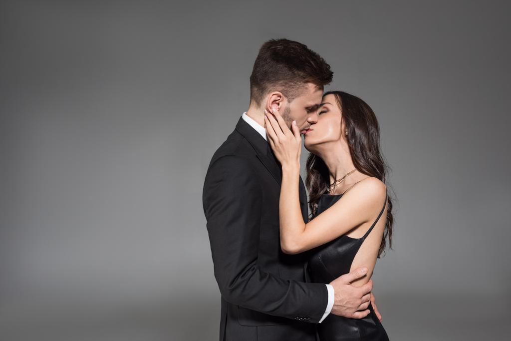hermosa elegante pareja besándose y abrazando aislado en gris
  - Foto, imagen