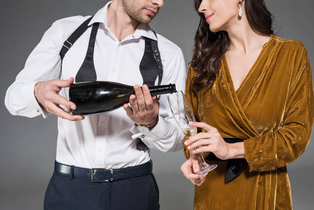 recortado vista de novio verter champán para novia aislado en gris
 - Foto, Imagen