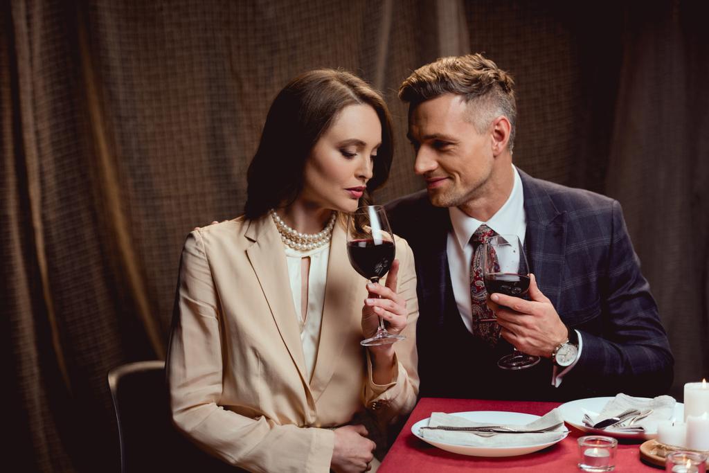красива пара тримає окуляри червоного вина під час романтичного побачення в ресторані
 - Фото, зображення