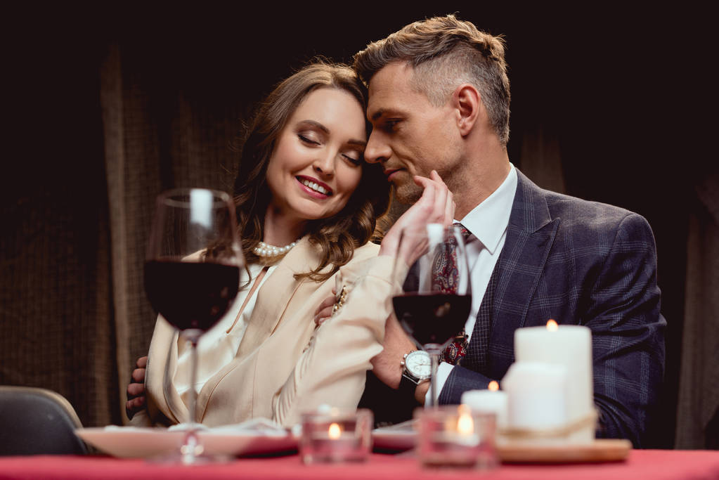 belle femme souriante toucher doucement le visage de l'homme pendant la date romantique dans le restaurant
 - Photo, image
