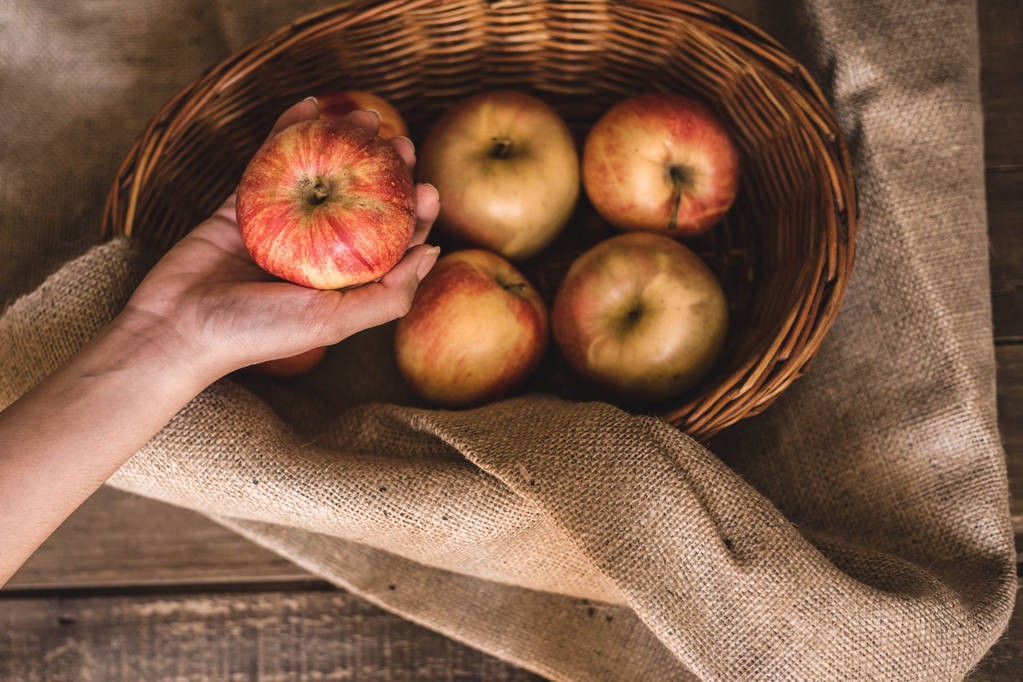 Φρεσκομαζεμένα μήλα σε ένα ψάθινο καλάθι - Φωτογραφία, εικόνα