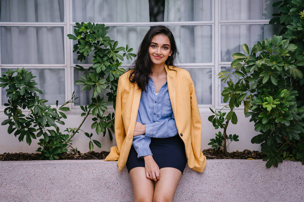 modische, elegante und junge indische Asiatin im Retro-Outfit. Sie trägt eine gelbe Jacke über einem bequemen Sommeroutfit. - Foto, Bild