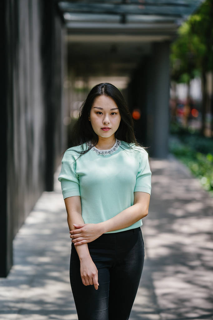 Retrato de una joven, sexy y glamorosa mujer asiática durante el día. Lleva un suéter verde menta.
 - Foto, imagen