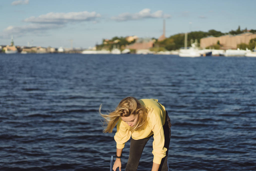красивая молодая женщина в красном плаще катается на частной яхте. Стокгольм, Швеция
 - Фото, изображение