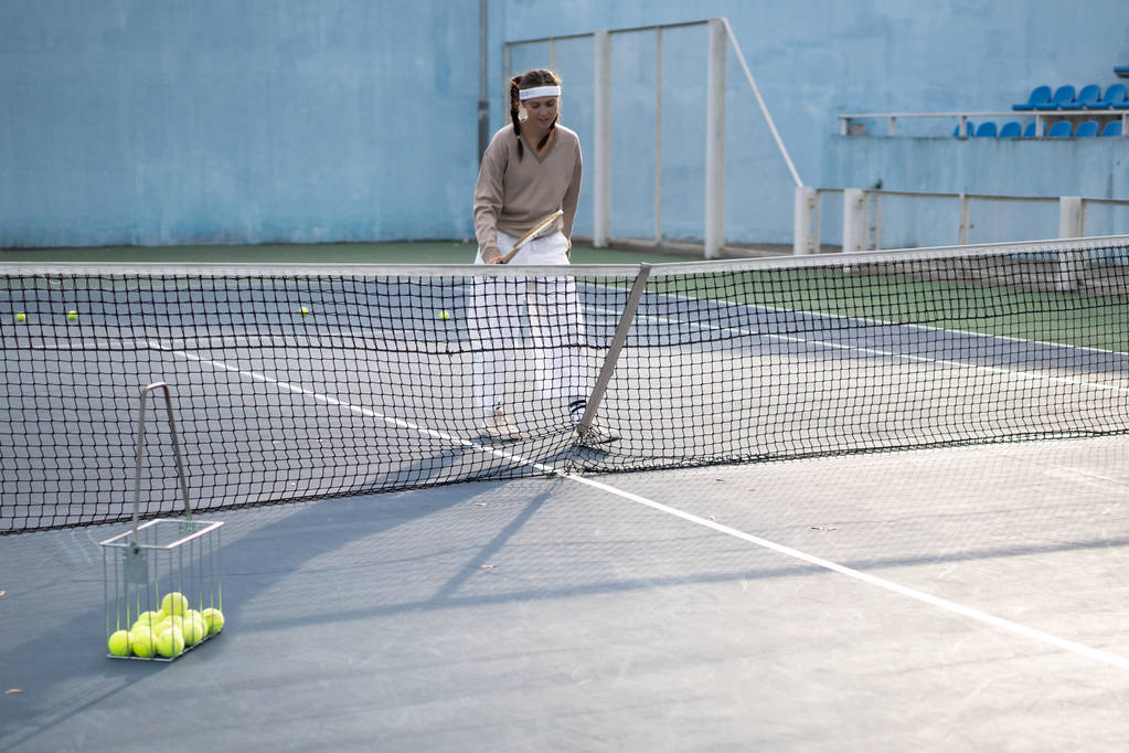 若い女性がテニスをしていて - 写真・画像