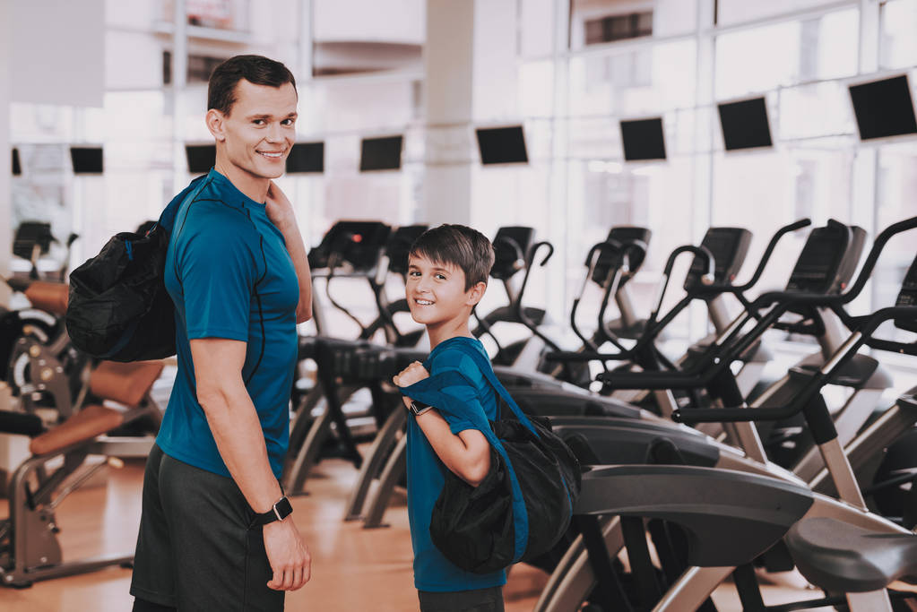 Young Father and Son near Treadmills in Modern Gym. Healthy Lifestyle Concept. Sport and Training Concepts. Modern Sport Club. Sport Equipment. Family Sport. Running Tracks. Parent with Child. - Photo, Image