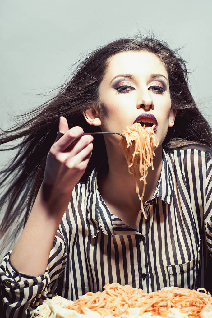Funny young pretty woman eating spaghetti tomato - Photo, Image
