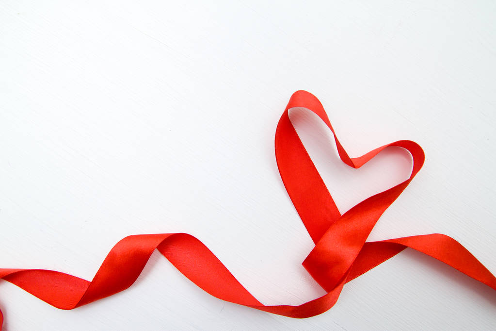Καρδιά σχήμα από κόκκινη κορδέλα σε λευκό ξύλινο φόντο. αντίγραφο χώρο Valentines και 8 Μαρτίου έννοια Ημέρα της Μητέρας Γυναίκας - Φωτογραφία, εικόνα