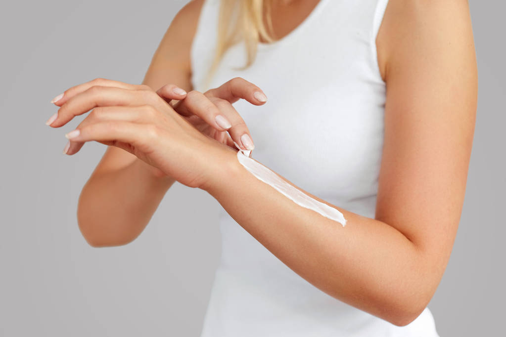 Closeup της γυναικείας χέρια εφαρμογή κρέμα χεριών. Περιποίηση χεριών δέρματος. Οι γυναίκες χρησιμοποιούν λοσιόν σώματος στα όπλα σας. Ομορφιά και σώμα φροντίδα έννοια - Φωτογραφία, εικόνα