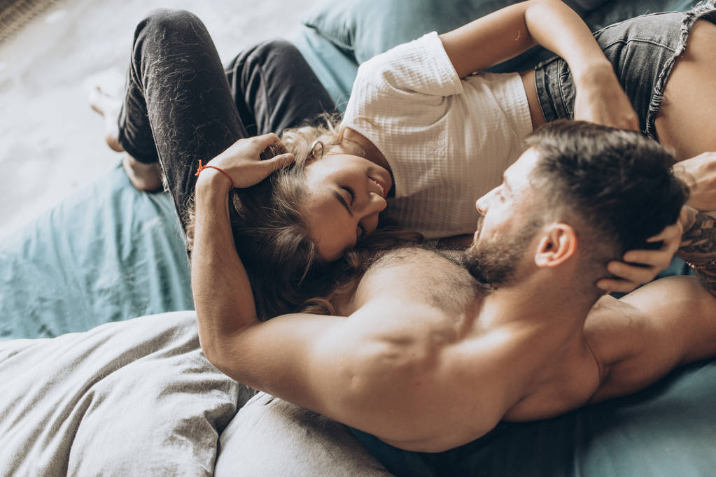 красивая любящая пара целуется в постели - Фото, изображение
