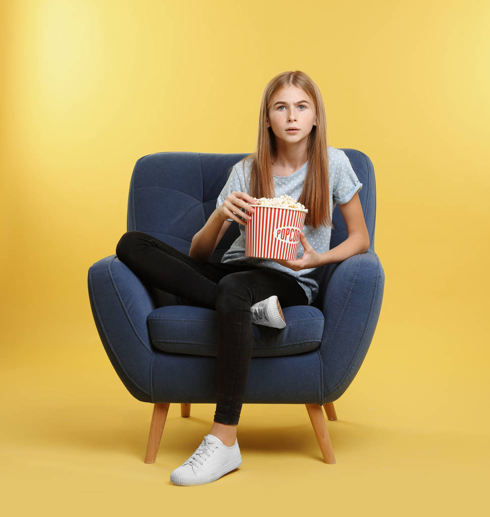 Érzelmi tizenéves lány alatt mozi pattogatott kukorica fehér háttér megjelenítése - Fotó, kép
