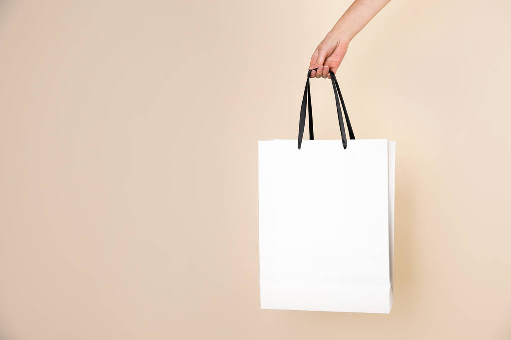 Woman holding paper shopping bag on color background. Mock up for design - Photo, Image