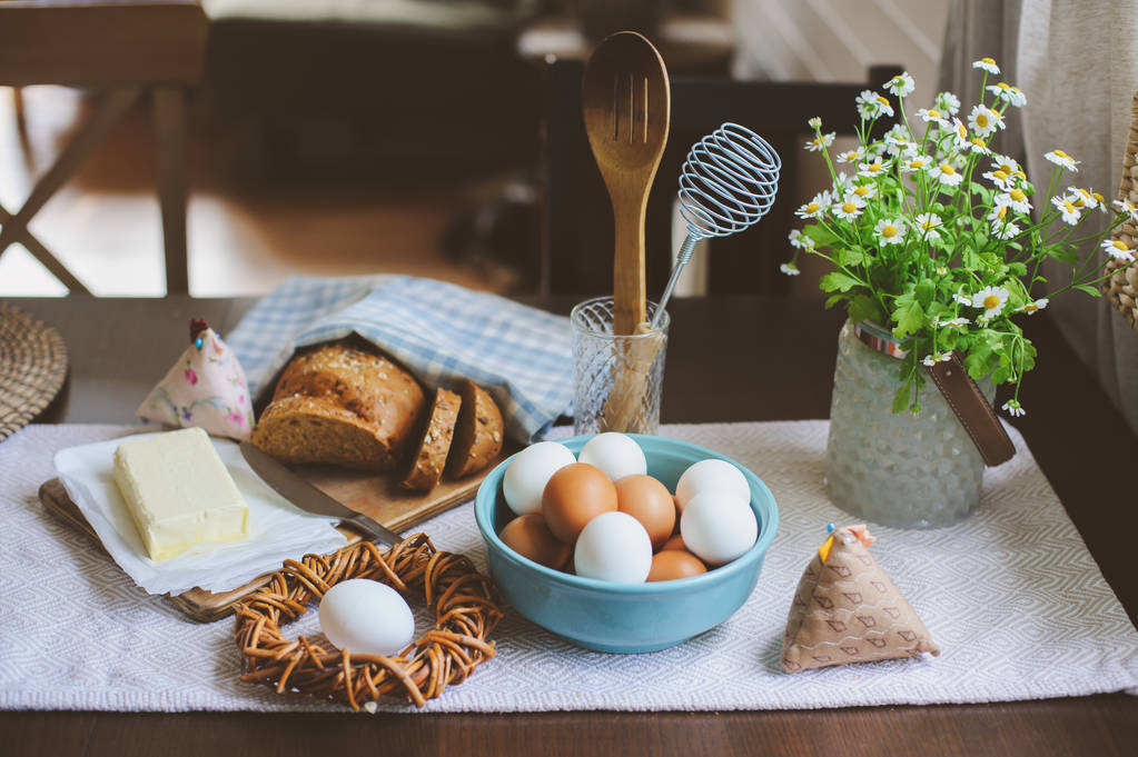 desayuno campestre en la cocina casera rústica con huevos de granja, mantequilla, pan integral y leche. Comida orgánica casera, concepto de Pascua
.   - Foto, Imagen