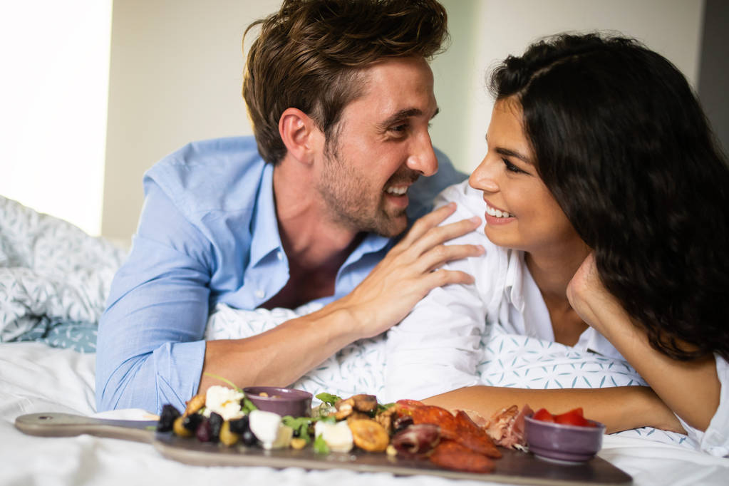 若い夫婦のベッドで食べている朝食 - 写真・画像