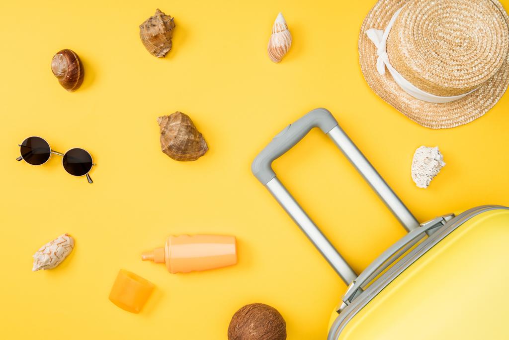 vue de dessus des coquillages, noix de coco, lunettes de soleil, bagages et chapeau de paille sur fond jaune
 - Photo, image