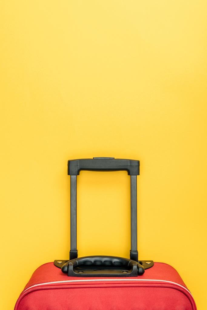 top view of red baggage with handle on yellow background - Photo, Image