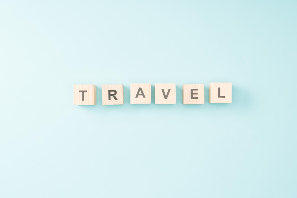 青の背景に旅行レタリングと木製キューブの平面図 - 写真・画像