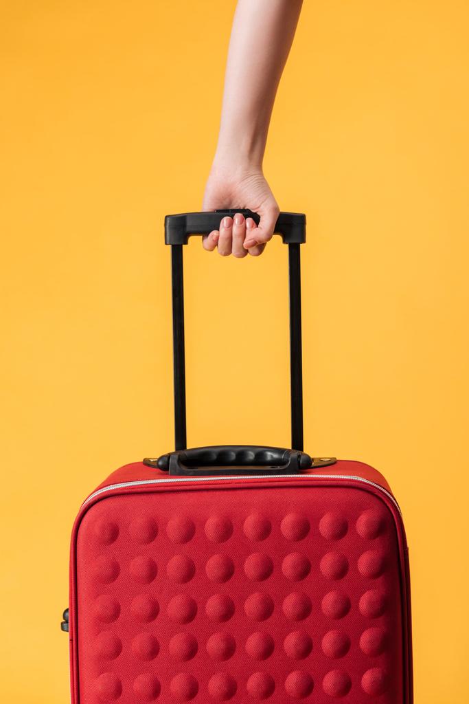 rajattu näkymä nainen tilalla punainen matkalaukku eristetty keltainen
 - Valokuva, kuva