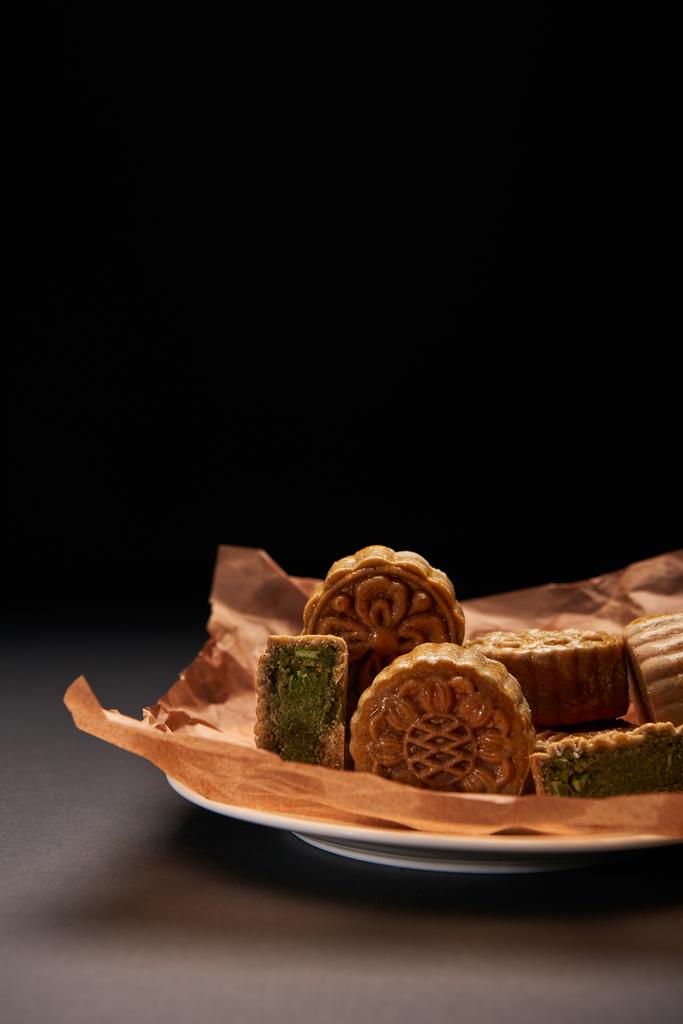 mooncakes chinois traditionnels sur plaque isolée sur noir avec espace de copie
 - Photo, image