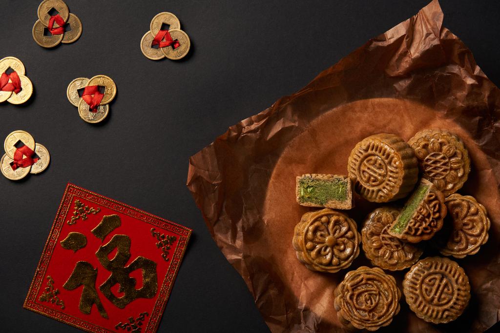 Widok z góry z tradycyjnych mooncakes z chińskich talizmany na czarnym tle - Zdjęcie, obraz