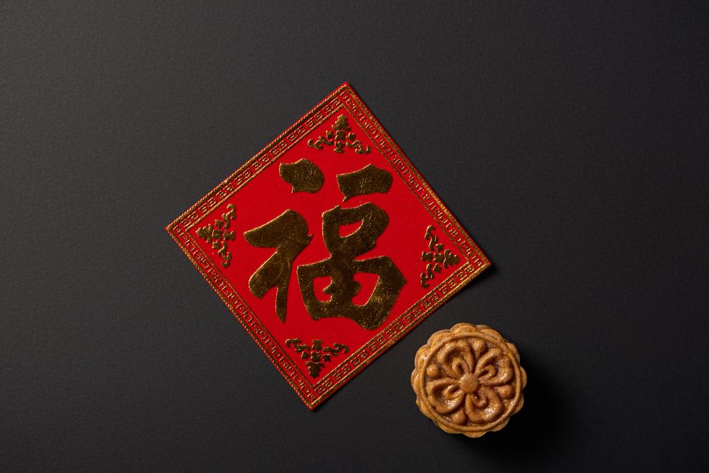 pohled shora tradiční mooncake a čínské hieroglyf izolované na černém pozadí - Fotografie, Obrázek