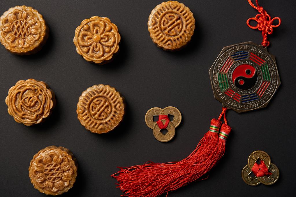 Widok z góry z tradycyjnych mooncakes z chińskich talizmany na czarnym tle - Zdjęcie, obraz