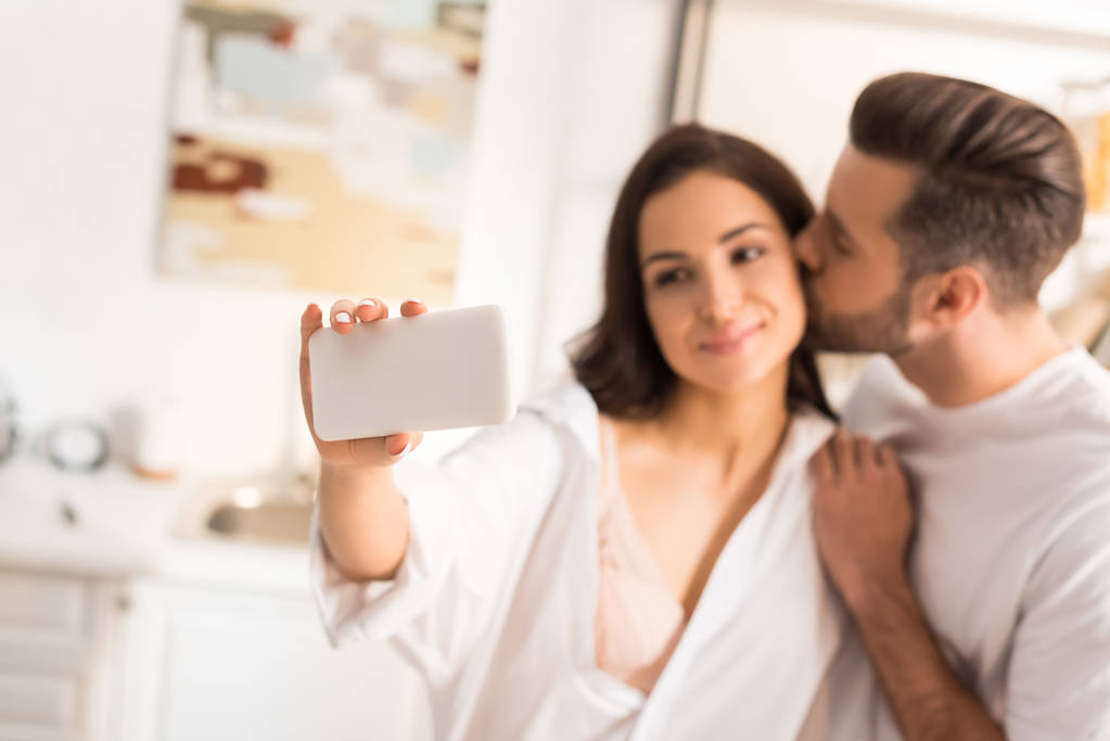 beau couple embrasser et prendre selfie sur smartphone à la maison
 - Photo, image