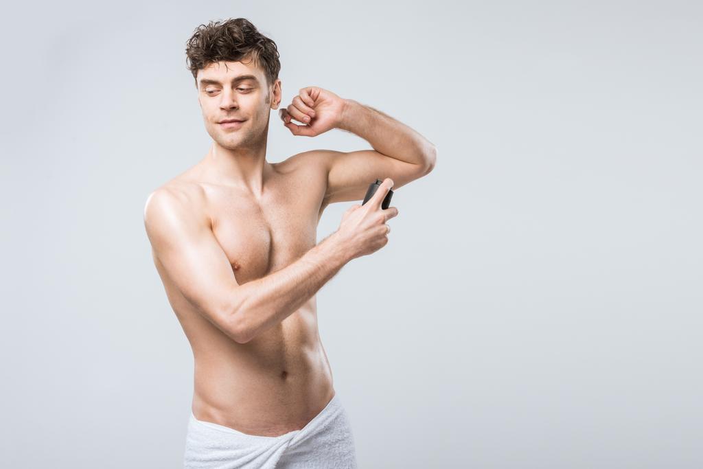 красивый мужчина без рубашки, распыляющий дезодорант, изолированный от серого
 - Фото, изображение