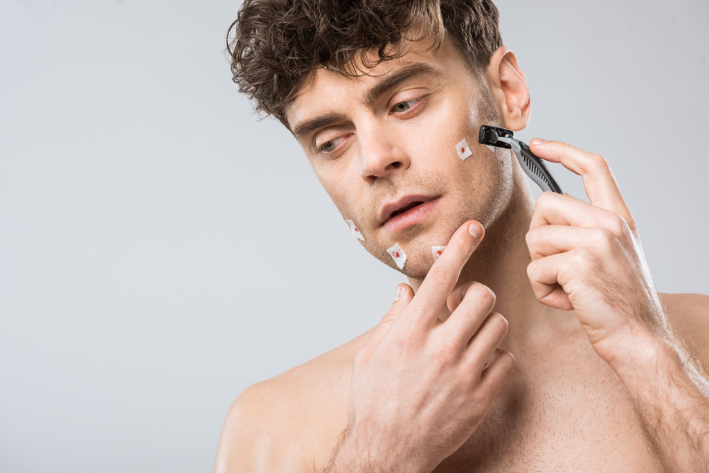 hombre infeliz con maquinilla de afeitar después de mal afeitado, aislado en gris
 - Foto, imagen