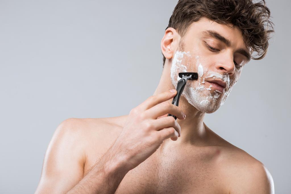 красива біла людина піна на обличчі голиться бритвою, ізольована на сірому
 - Фото, зображення