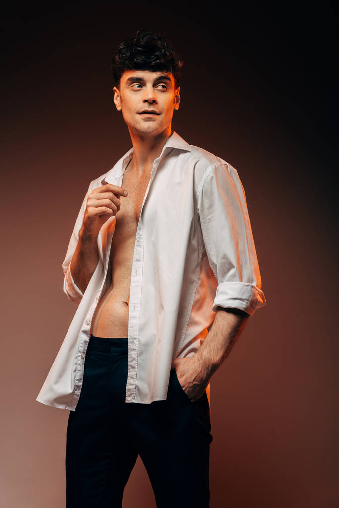 bonito sexy homem posando no branco camisa, isolado no marrom
 - Foto, Imagem