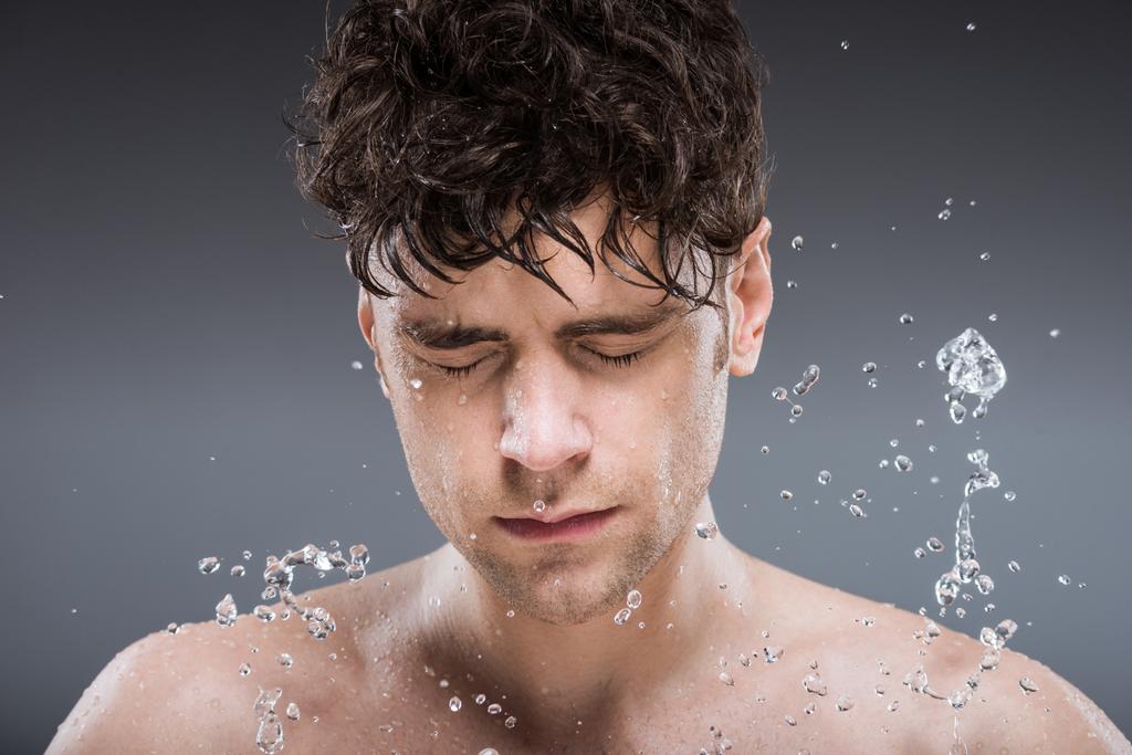 Genç adam yüz gri izole suyla yıkama - Fotoğraf, Görsel