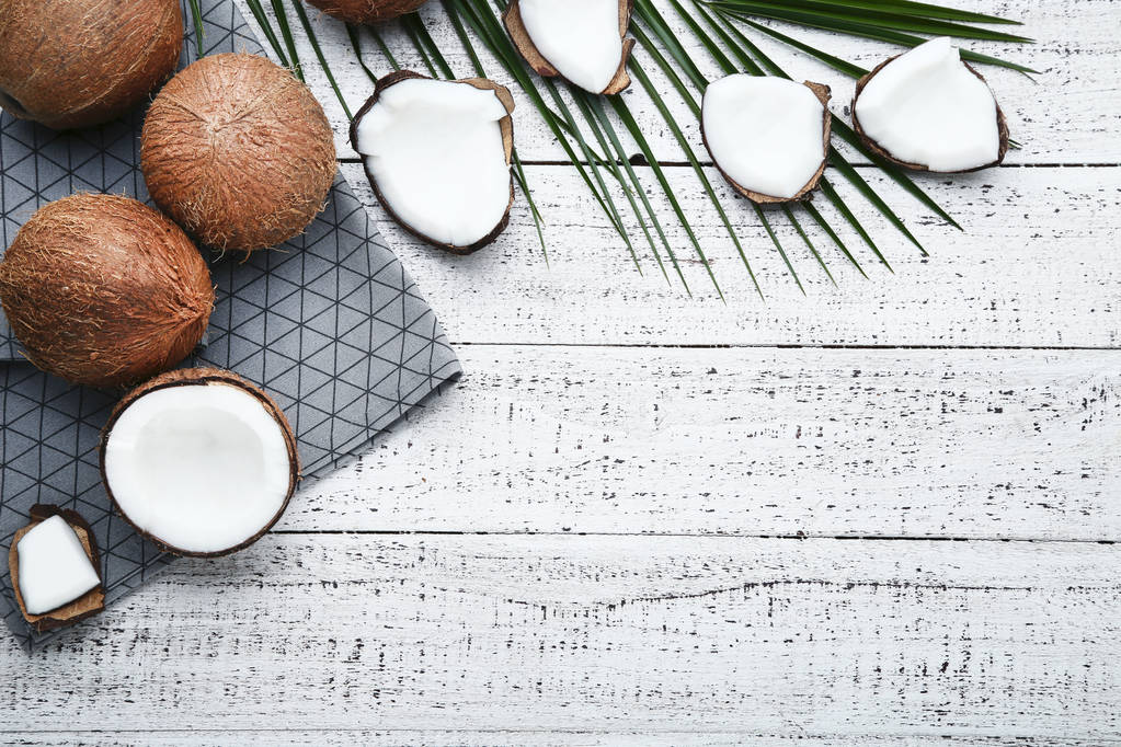 Zralé kokosy s ubrousek a palmového listí na dřevěný stůl - Fotografie, Obrázek