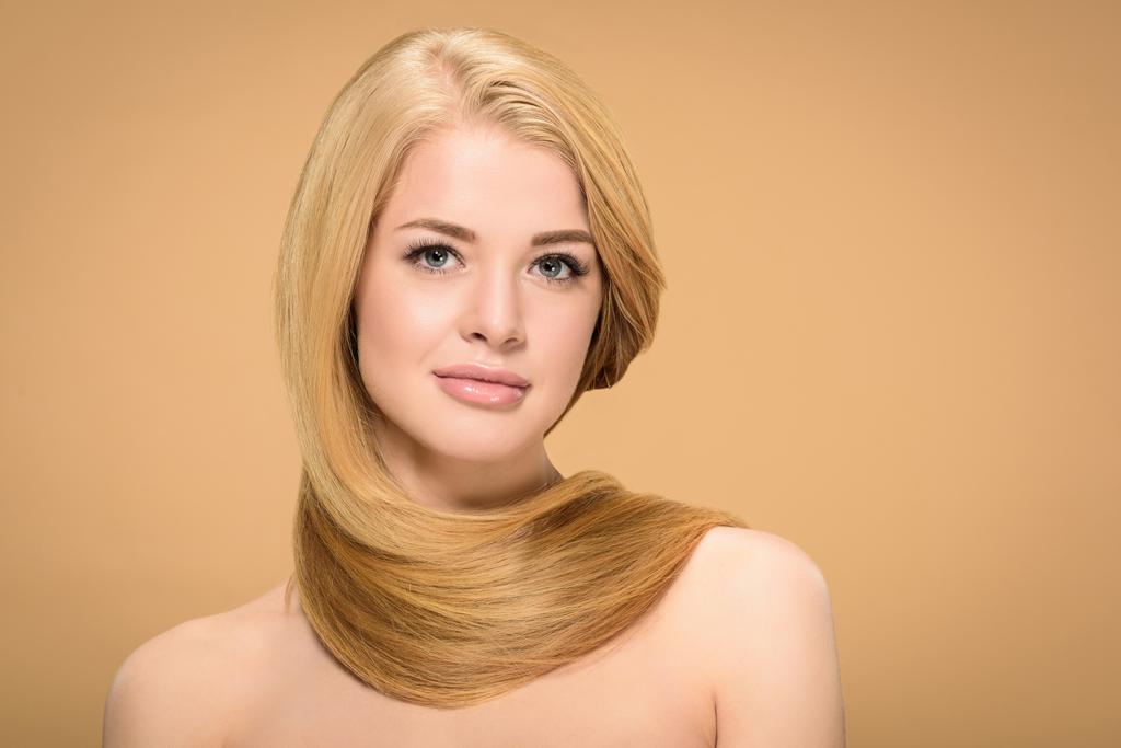 Charmante junge Frau mit blonden, glänzenden Haaren blickt in die Kamera  - Foto, Bild