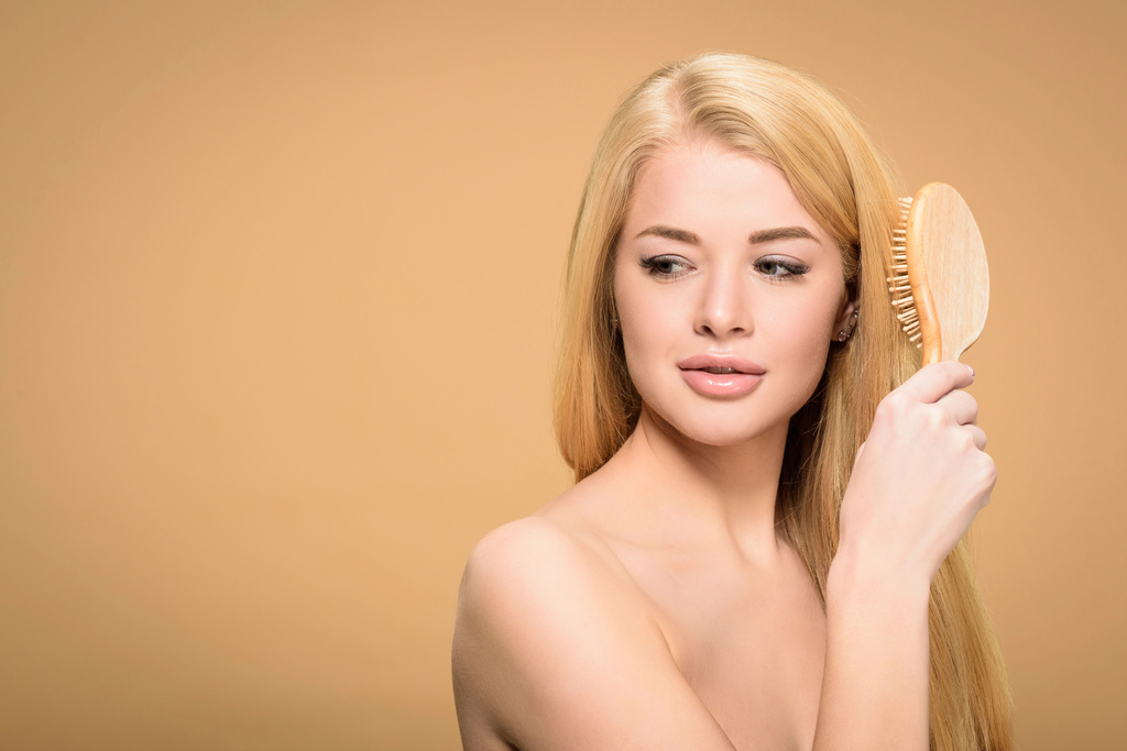 Studio laukaus houkutteleva nuori nainen harjaamalla hiukset
  - Valokuva, kuva