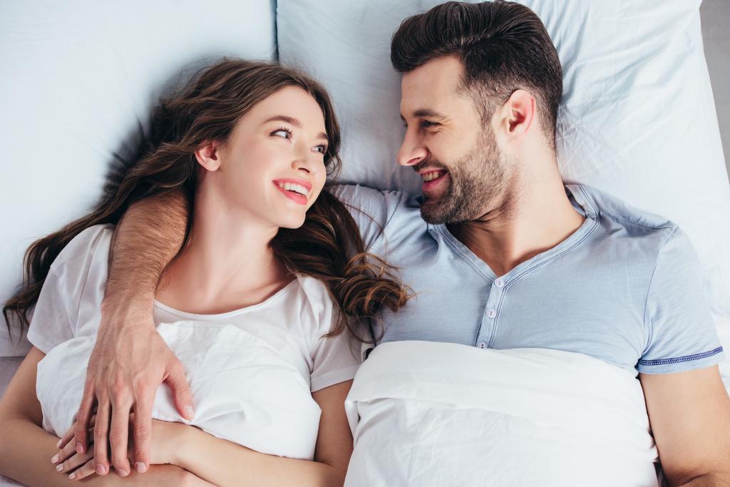 fidanzato e fidanzata sdraiato su morbide lenzuola bianche in camera da letto
 - Foto, immagini