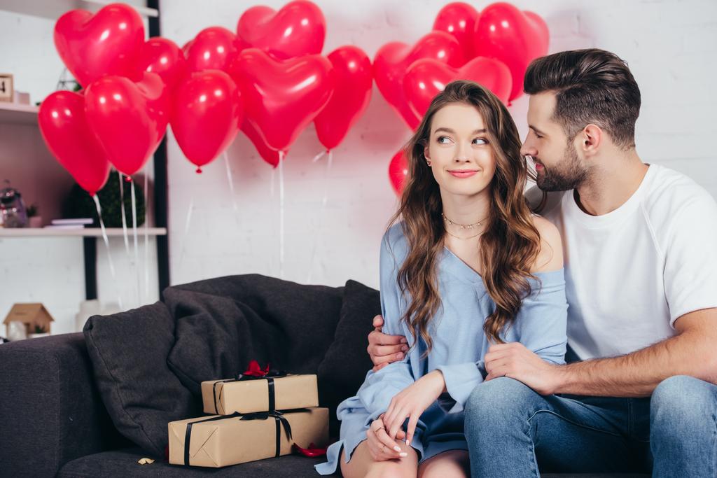 homem feliz olhando para a mulher no quarto decorado para o dia de São Valentim
 - Foto, Imagem