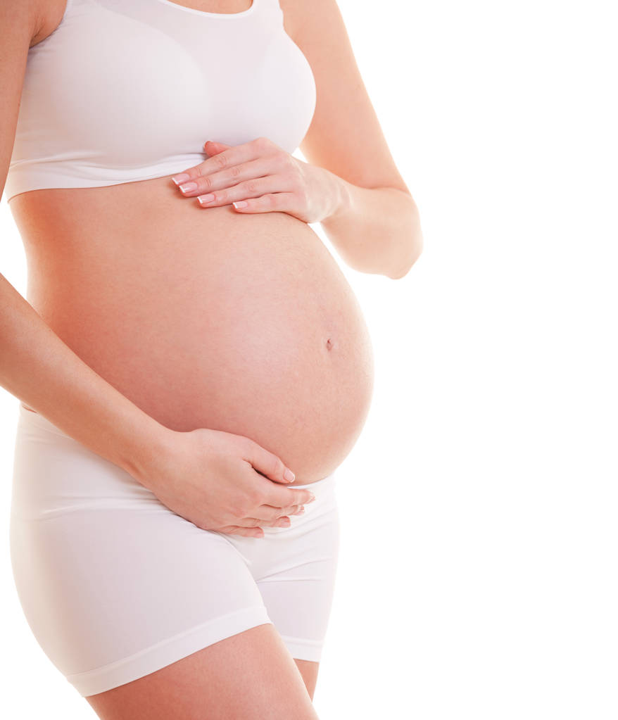 Képzeld el, ahogy egy terhes nő megérinti a nagy hasát. Közelről. Anyaság, terhesség, emberek és elvárások. Gyereket váró terhes nő - Fotó, kép