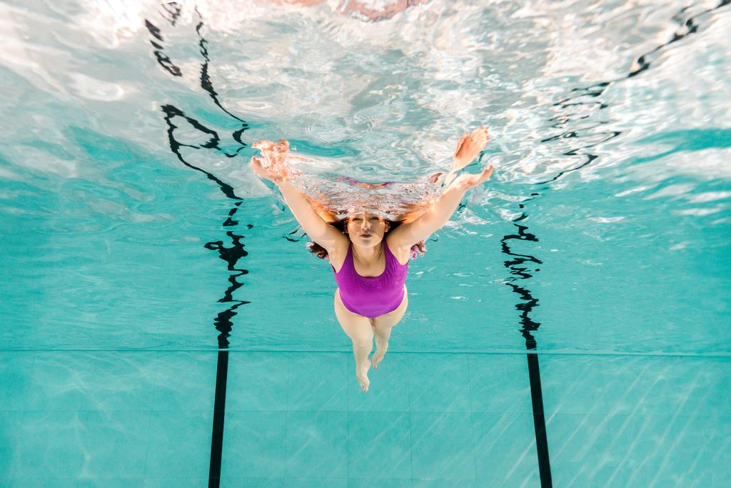  mujer nadando bajo el agua en traje de baño en agua azul
 - Foto, Imagen