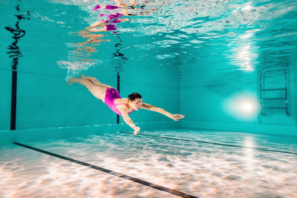 Kobieta, pływanie w różowe stroje kąpielowe i googles pod wodą - Zdjęcie, obraz