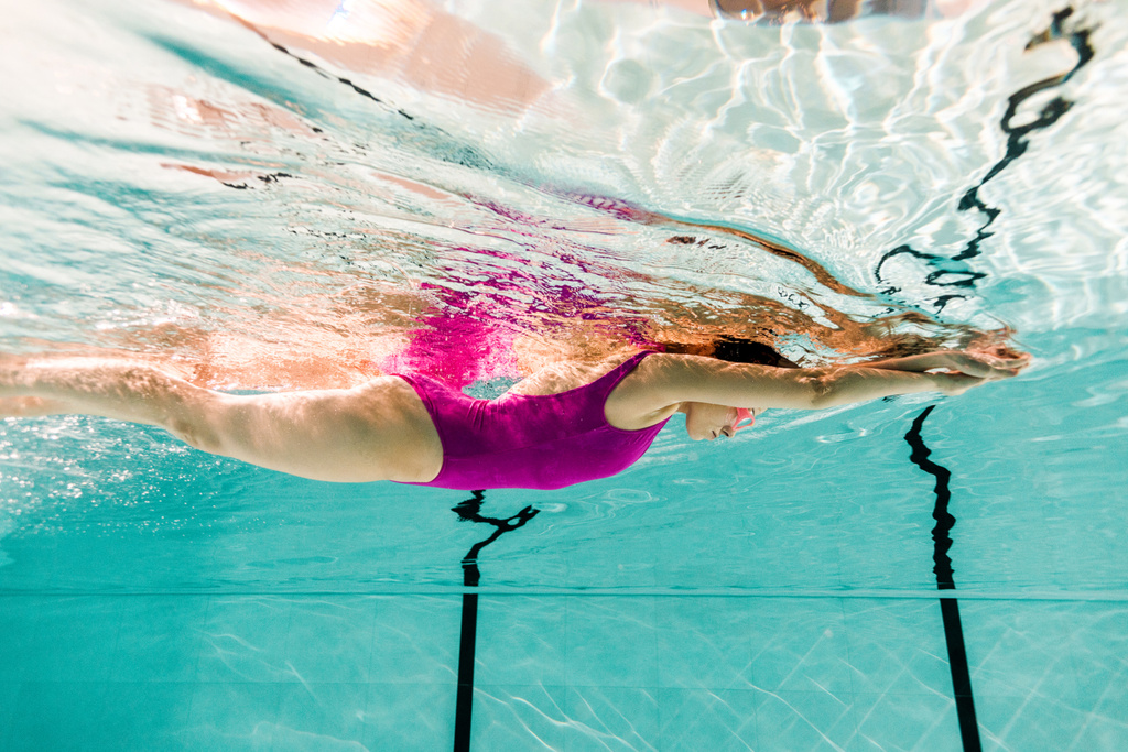 Frau schwimmt unter Wasser in Schwimmbad mit blauem Wasser - Foto, Bild